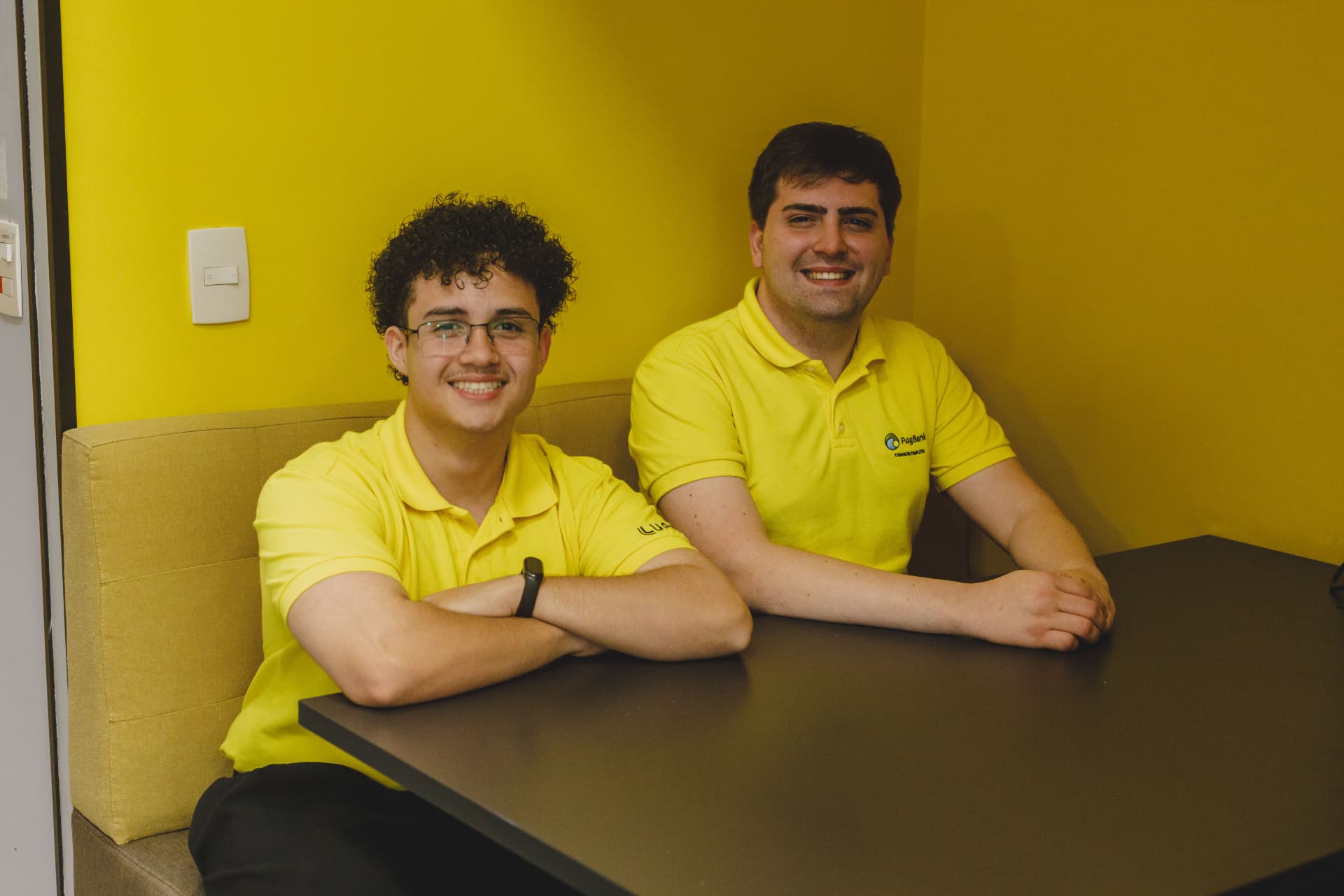 Dois PagTalents de camisa amarela sorrindo no PagBank
